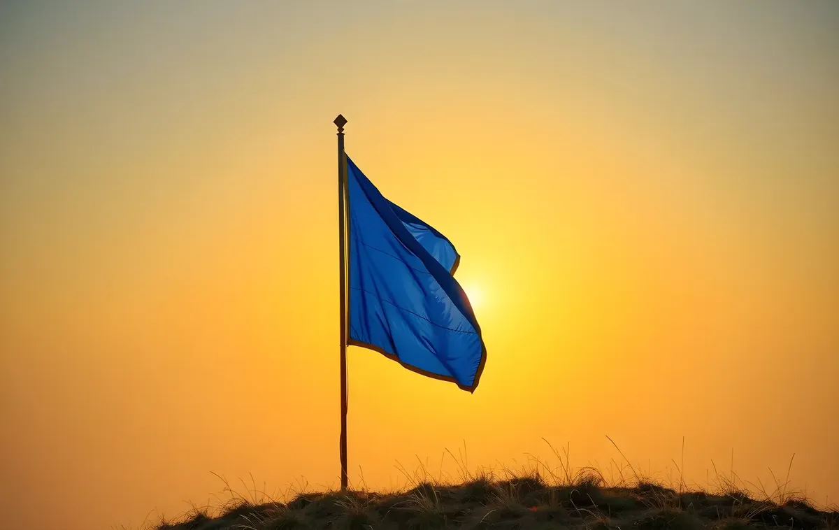 A blue banner flying high on a hilltop at sunrise